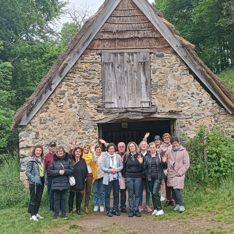 Grupo da Reserva d'Emoções junto a uma casa antiga de pedra com telhado de colmo